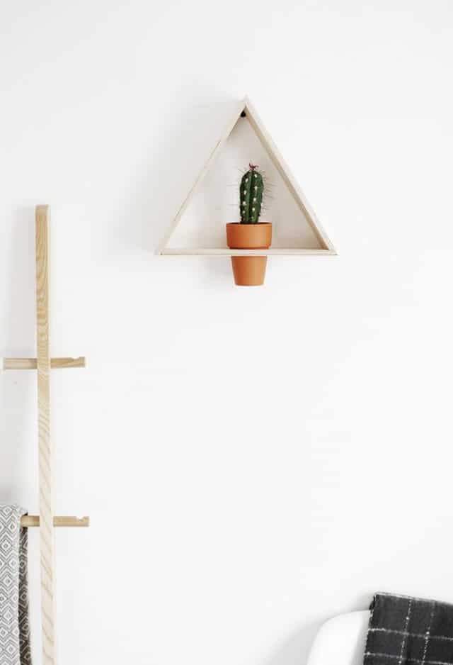 Este triángulo de madera se fija a la pared y se inserta una maceta normal de suculenta, terracota o plástico en un agujero, creando un hermoso soporte de pared para plantas.